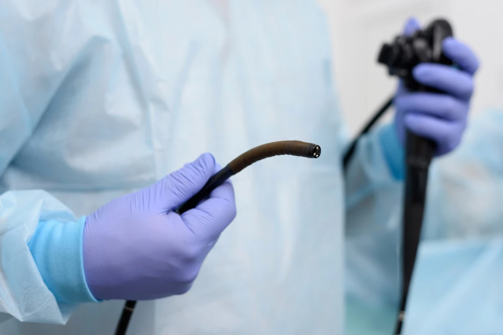 Colorectal surgeon holding a colonoscope for a colonoscopy procedure.