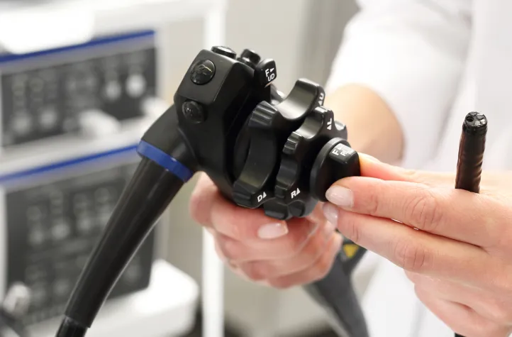 An endoscope being adjusted for a colonoscopy procedure.